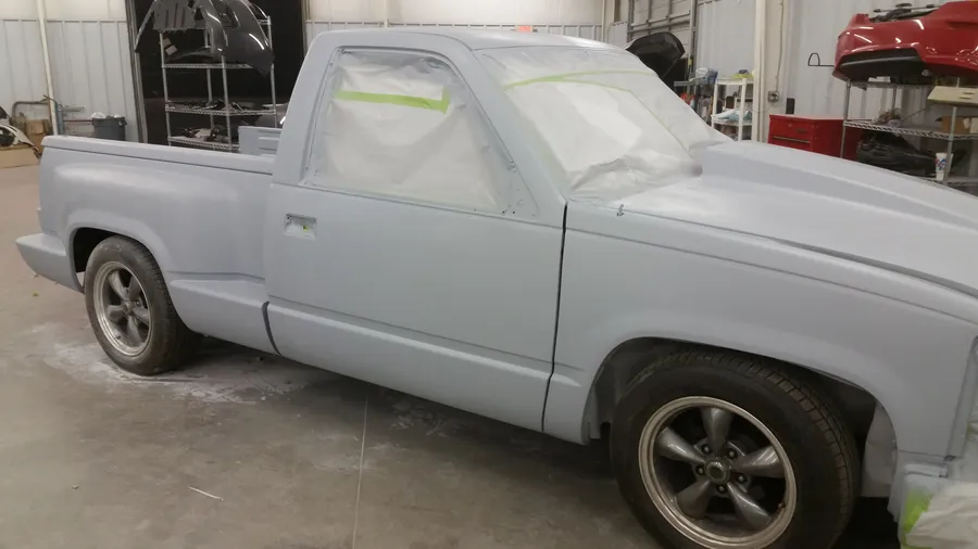 Parrish Collision shop floor with vehicles in active stages of body repair, panel work, and paint preparation in eastern North Carolina